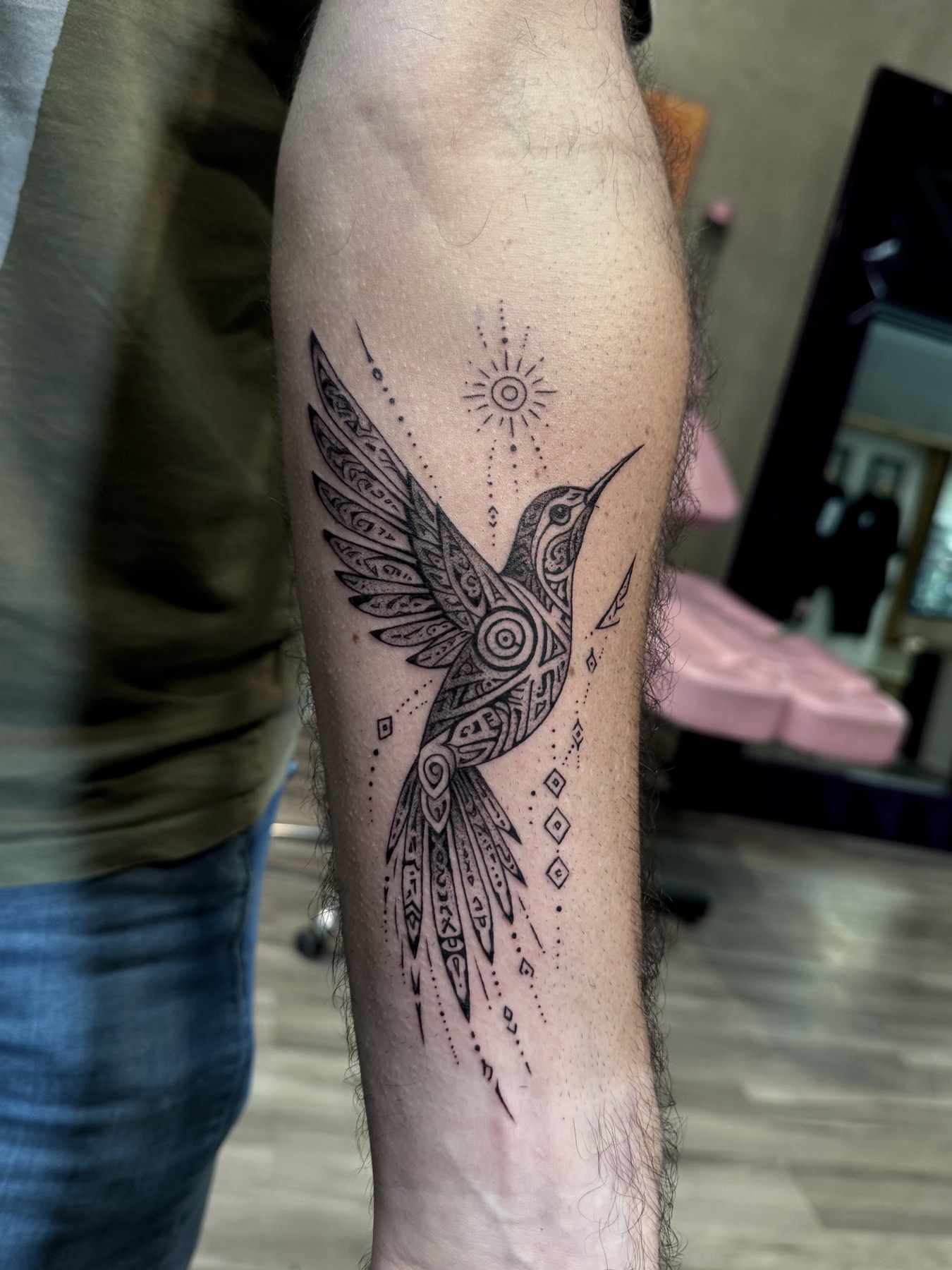 Geometric black ink hummingbird tattoo by Mike Villamizar